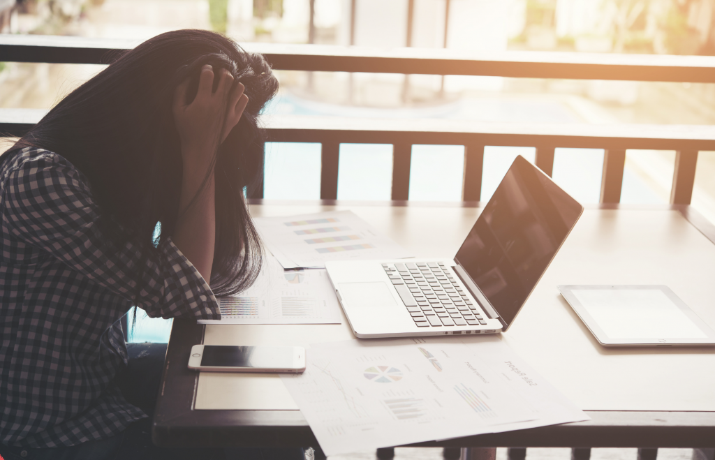 Frau frustriert vor Laptop Auszeit vom Alltag nehmen